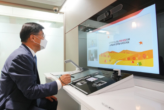 최홍영 BNK경남은행장이 창원 양덕동금융센터에서 'BNK 디지털 데스크'를 활용해 고객상담을 하고 있다. 경남은행 제공